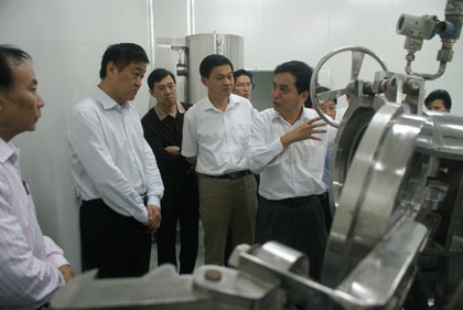 繆曉青教授向省委常委、常務副省長張昌平介紹自己研發的高節能保鮮濃縮干燥機和疊壓高能保鮮濃干燥機